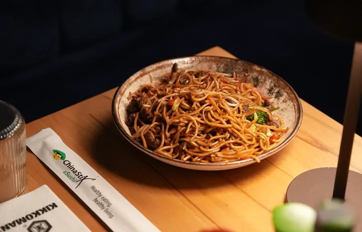 ChinaStix Maslak'ta ahşap masada servis edilen noodle tabağı
